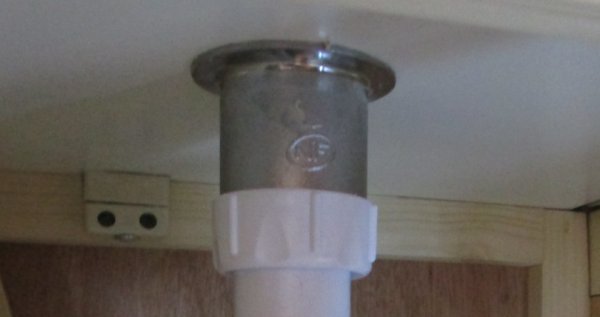 Underside of vanity unit top showing waste water fitting